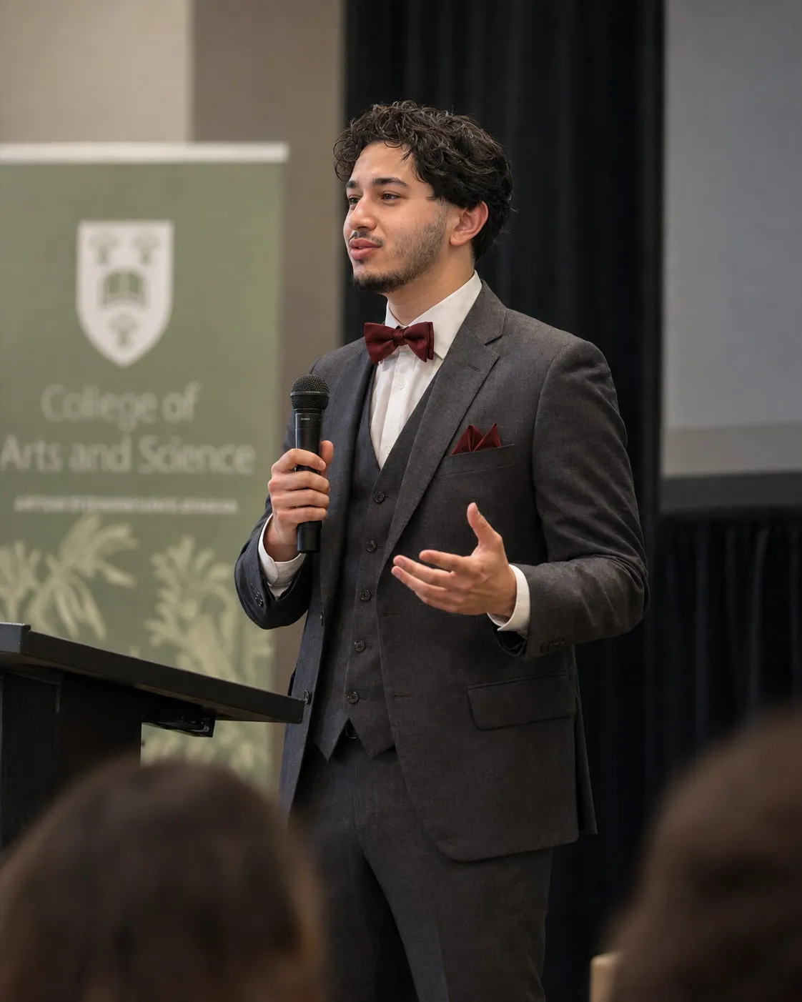 Usama Kelani speaking on stage at a University of Saskatchewan event